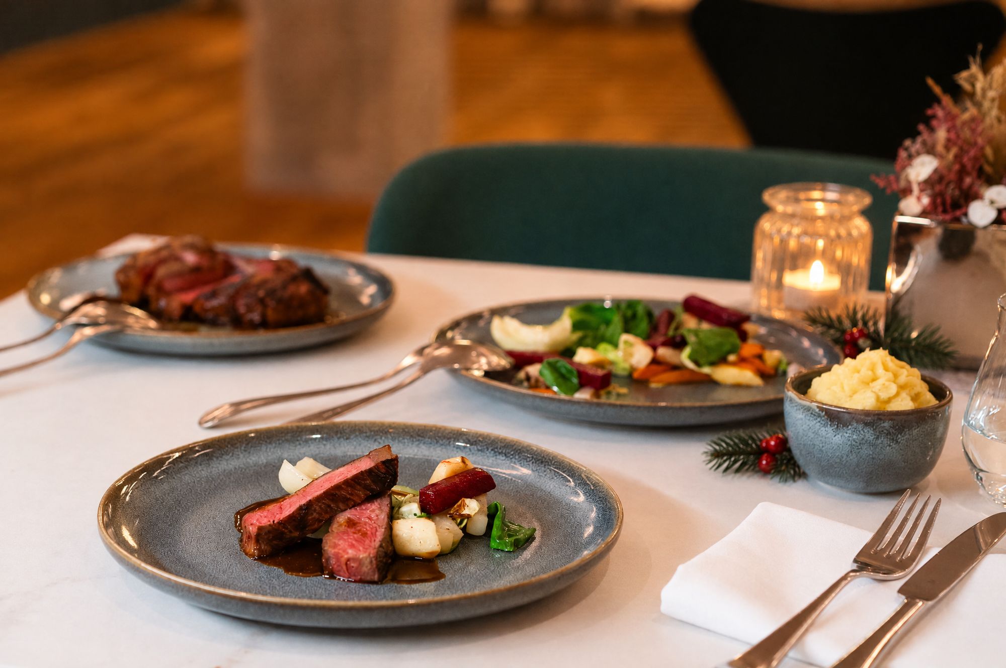 Gedeckter Tisch mit Weihnachtsmenü und Kerze im Restaurant der Ehemaligen Sparkasse